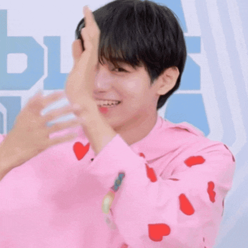 a young man wearing a pink hoodie that says holly