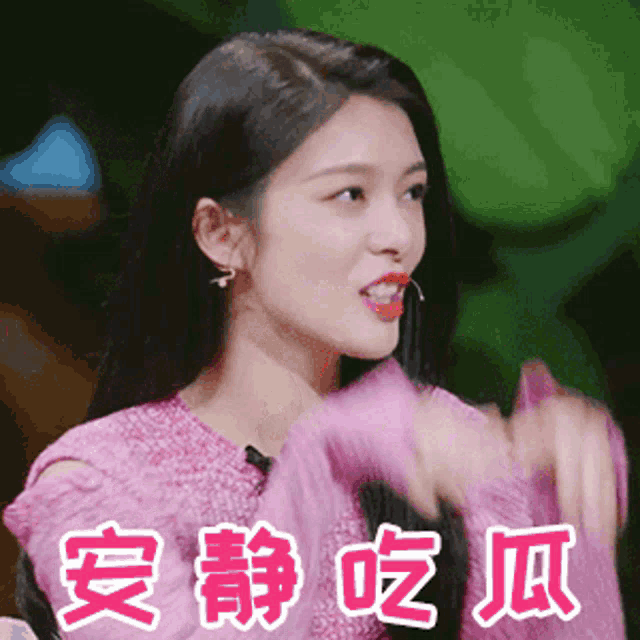 a woman wearing a pink sweater with chinese writing on it