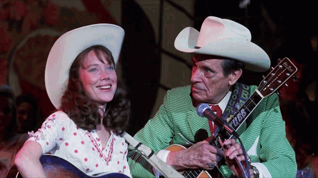 a man in a green suit is playing a guitar with a strap that says ' tz88 ' on it